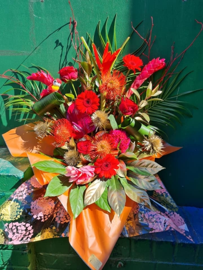 Tropical paradise - This fresh flower arrangement is made with beautiful exotic flowers, sprayed foliage and even a decorative little bird.